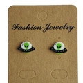 Detail view of creative UFO alien stud earrings on a kraft paper display card - Alien Head Style