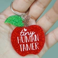Close-up of glitter apple teacher keychain featuring tiny HUMAN TAMER white lettering - tiny HUMAN TAMER (Apple)
