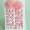 Nahaufnahme der rosa glitzernden BRIDE Ohrringe mit Pompons für die Hochzeit - Rosa Pelzball Braut Glitzer