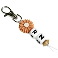 Porte-clés infirmière RN avec fleur en silicone et perle en bois sur fond blanc épuré - Rose