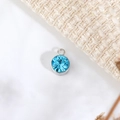 Dettaglio del ciondolo pietra portafortuna celeste con castone in metallo argento lucido - Diametro 6mm / Marzo (P1239)