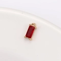 Detailed macro view of a red rectangular crystal pendant with a gold metal frame - 4mm*8mm / Red (P1732)