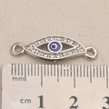 Macro shot of evil eye jewelry connector with rhinestones measuring 2.6cm on a ruler - Shuttle Evil Eye Style (P0080)