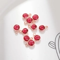 Close-up of nine 6mm round faceted red crystal pendants with rose gold metal frames - 6mm / Rose Gold - Red (October)