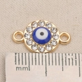 Macro detail of 20mm golden Evil Eye jewelry connector with rhinestones and ruler for scale - Round Disc Evil Eye Style (P0328)