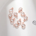 Macro detail of 6mm round glass charms with rose gold copper plating for DIY jewelry making - 6mm / Rose Gold - Clear (April)