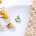 Detailed view of a faceted 6mm green birthstone pendant with silver metal setting - 6mm / Silver - Green (August)