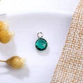 Macro shot of 6mm green birthstone crystal pendant with silver setting on ceramic background - 6mm / Silver-Green (May)