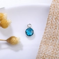 Close-up of a faceted 6mm blue birthstone crystal pendant in a silver metal frame - 6mm / Silver - Blue (December)