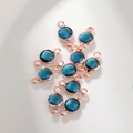 Detailopname van donkerblauwe geboortesteen bedeltjes met dubbele lussen in roségoud - 6mm / Rozegoud December (P2457)