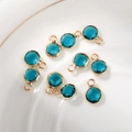 Macro detail of 6mm blue round faceted birthstone charms with gold copper bezel for DIY - 6mm / Gold - Blue (December)