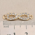 Nahaufnahme eines goldenen Unendlichkeit-Anhängers mit Strass und Maßtabelle - Pavé Unendlichkeits Stil (P2577)
