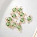 Macro-opname van 6mm groene geboortesteen bedeltjes met gefacetteerd glas en goud - 6mm / Gouden Rand Juli (P2471)