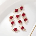 Detailopname van 6mm donkerrode geboortesteen bedeltjes met dubbele gouden verbindingen - 6mm / Gouden Rand Januari (P2474)
