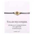 Macro detail of hand-woven compass bracelet on card with North South West East engraving - Gold Compass Rose Braided Bracelet (B2945-Bracelet)