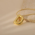 Detail of golden bubble letter D pendant with polished finish on a sleek snake chain - Letter D Style (24WN028)
