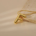 Detail of gold bubble letter F pendant with polished finish on a sleek snake chain - Letter F Style (24WN028)