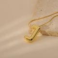 Detail of 3D balloon-style letter J pendant on a gold snake chain over natural stone - Letter J Style (24WN028)