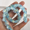 Macro detail of heart-shaped blue iridescent opal glass beads with gold foil inside - 6# Sky Blue Iridescent Heart