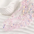 Vista macro de cuentas de estrella rosa iridiscente en un plato decorativo blanco - Rosa Multicolor
