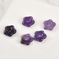 Makroaufnahme von fünf blütenförmigen Amethyst-Steinperlen für Schmuck DIY auf weißem Stein - Amethyst Blume