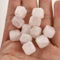 Roze kwarts kralen in de hand om de grootte te tonen voor DIY sieraden maken - Rozenkwarts Kubus