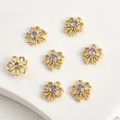 Macro detail of seven gold plated hollow floral pendants with central purple zircons - Purple Zirconia Bow 14K Gold (10.6x10mm)