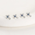Detailed macro view of four snowflake charms with white cubic zirconia and blue center stones - White K Plated Blue Zircon Cross
