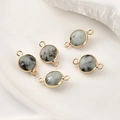 Macro detail of round marble stone connectors with gold plated edges for jewelry making - Black Spot Agate