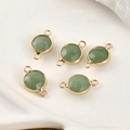 Macro view of natural green gemstone round connectors featuring faceted gold-plated bezels - Green Aventurine