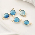 Detailed view of five blue faceted gemstone connectors with gold plated circular frames - Aqua