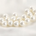 Macro shot of loose white round pearls with pre-drilled holes on white silk fabric - 8mm White Pearl Bead (Approx 7.95mm)