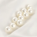 Close-up of premium cream faux pearls with pre-drilled holes on soft white silk fabric - 10mm White Pearl Bead (Approx 10mm)
