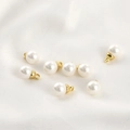 Dettaglio di ciondoli di perle finte bianche con ganci in metallo dorato per gioielli DIY - Ciondolo Perla Bianca 6mm con Cappuccio Dorato