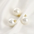 Dettaglio di tre ciondoli di perle bianche con cappucci dorati su seta bianca - Ciondolo Perla Bianca 14mm con Cappuccio Dorato