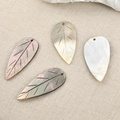Detailed view of four leaf-shaped shell pendants with natural iridescent luster and veins - Large Leaf Style