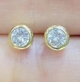 Klassische runde Zirkonia-Ohrstecker mit gehämmerter Goldfassung am Finger präsentiert - Runde Zargenfassung Ohrstecker / Goldene Basis-Weißer Transparenter Zirkonia