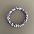 Dettaglio delle perle in ceramica blu e bianche e dei distanziatori dorati del bracciale - 8mm