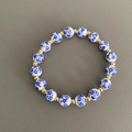Dettaglio macro del bracciale di perline in porcellana blu e bianca con distanziatori oro - 10mm