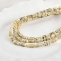Detailansicht von 4x10mm marmorierten Glasperlen mit silbernen Zwischenperlen auf Tablett - Beige Bild Textur Stil (P-11)