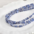 Nahaufnahme von 4x10mm hellblauen Millefiori-Glasperlen mit silbernen Zwischenperlen - Lila Blau Streifen Stil (P-11)