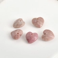 Detailed view of five 13mm faceted natural stone heart pendants with pre-drilled holes - Rhodochrosite Heart