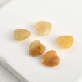 Macro detail of 13mm double-faceted ginger amber heart-shaped crystal beads for DIY jewelry - Yellow Aventurine Heart