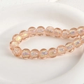 Macro shot of iridescent peach glass beads with gold foil texture on a white ceramic tray - 2# Pink Iridescent Square