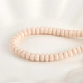Makroaufnahme fleischrosa Glassperlen in Abakusform mit Glanzfinish für DIY-Schmuck - Rosa Porzellan Abakus Perle