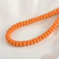 Makro-Detail von 5x8mm orangefarbenen Glasperlen für DIY-Armbänder und Schmuckzubehör - Orange Gelbe Abakus Perle