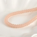 Makroaufnahme von 5x8mm rosa durchscheinenden Glasperlen für handgefertigten Schmuck - Rosenquarz Abakus Perle