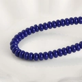 Vista macro de cuentas de vidrio azul oscuro pulido para la creación de pulseras y joyería DIY - Cuenta Ábaco Azul Real