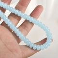 Primer plano de cuentas de vidrio azul claro 5x8mm sostenidas para joyería DIY - Cuenta Ábaco Jade Azul Lago