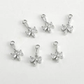 Vue macro de six pendentifs nœuds en zircone pour la création de bijoux DIY argentés - Or Blanc avec Zircone Blanche